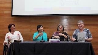 Cuatro mujeres en una mesa dando una charla.