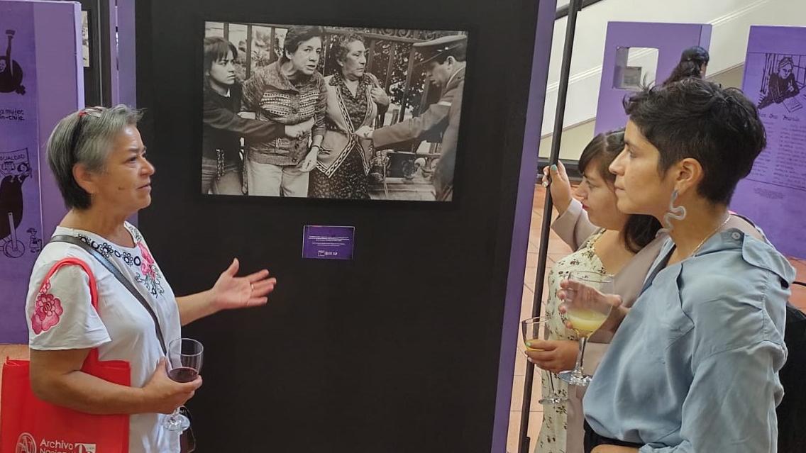 Mujer exponiendo ante una fotografía.