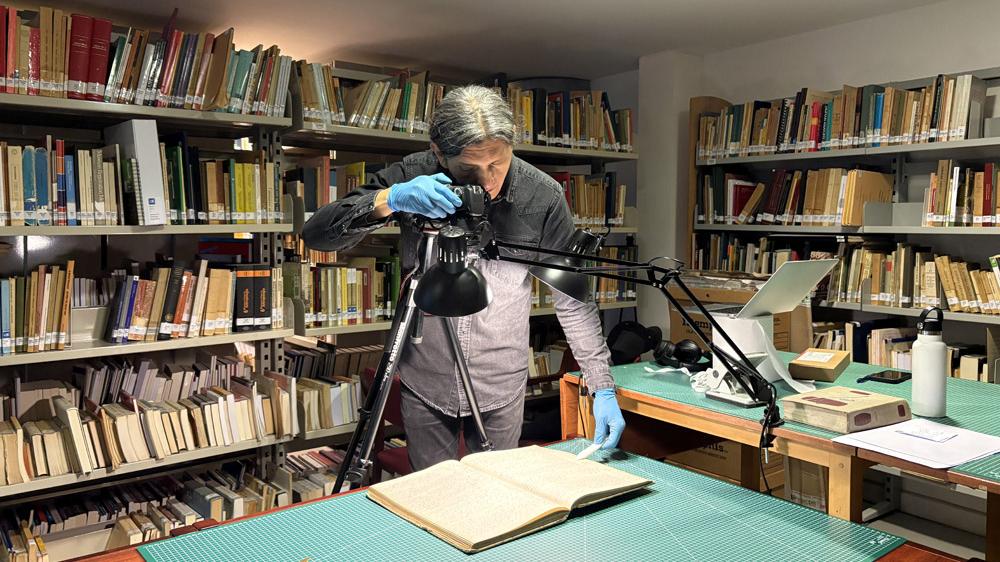 Persona fotografiando documentos.