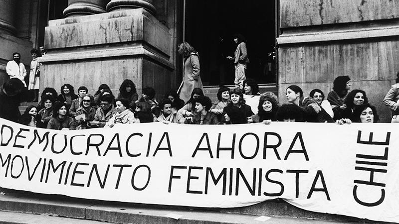 Mujeres con lienzo de protesta frente a la Biblioteca Nacional.