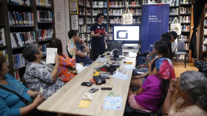 Gente en un taller frente a una mesa larga.