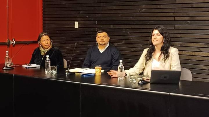 Personas exponiendo en una mesa, seminario.