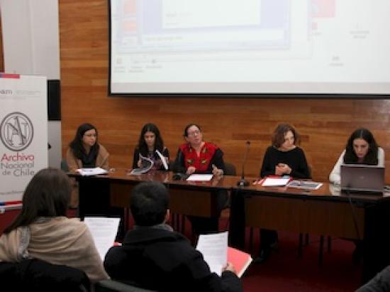 Mujeres en una mesa dando una charla.