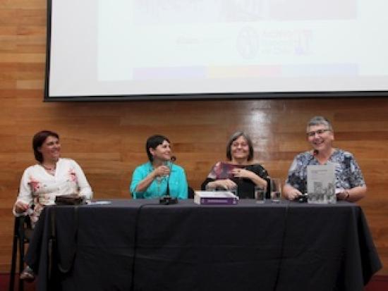 Cuatro mujeres en una mesa dando una charla.