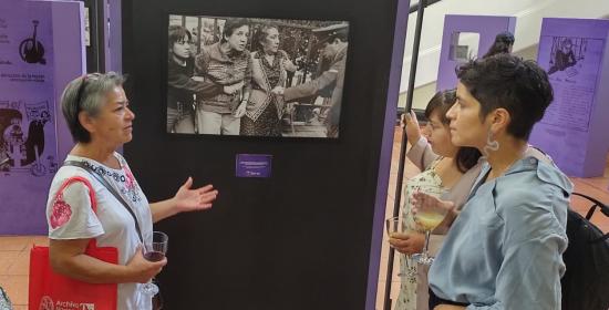 Mujer exponiendo ante una fotografía.