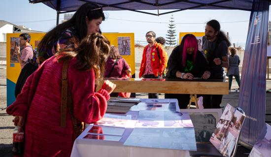 personas mirando documentos ubicados en una mesa.