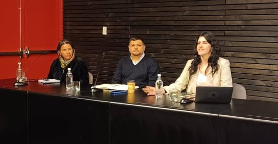 Personas exponiendo en una mesa, seminario.