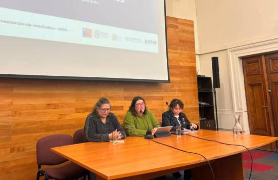 Tres mujeres en una mesa exponiendo, conservadoras archivos regionales.