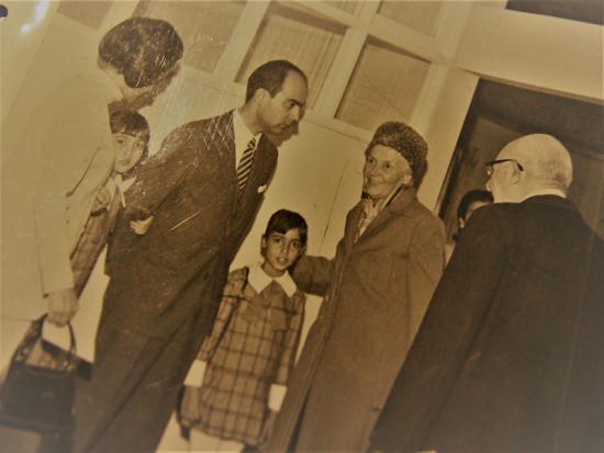 Fotografía en sepia con personas saludándose.