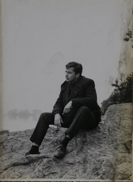 Foto joven sentado en un montículo de tierra.