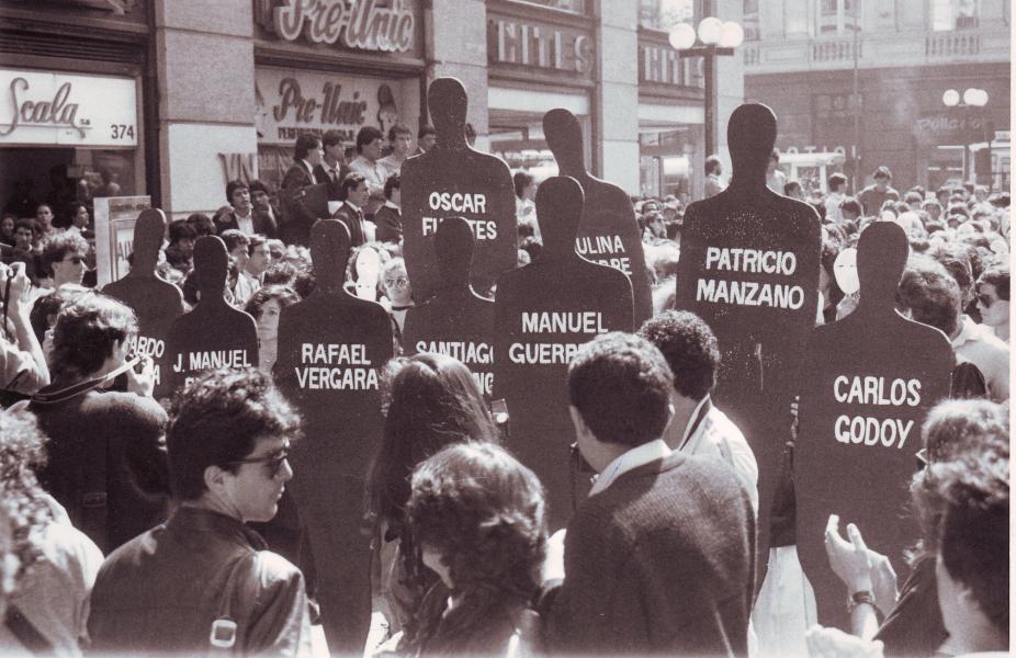 Manifestación de «Mujeres por la vida» en el centro de Santiago, con siluetas negras representando detenidos desaparecidos. Fotógrafo: Ricardo González. 29 de marzo de 1989. Fondo Archivo Fotográfico Fortín Mapocho. CL ARNAD AD-10-FFMAP-S56-FOT/FM B(04367). Archivo Nacional de la Administración. Fotografía grupo mujeres protestando.
