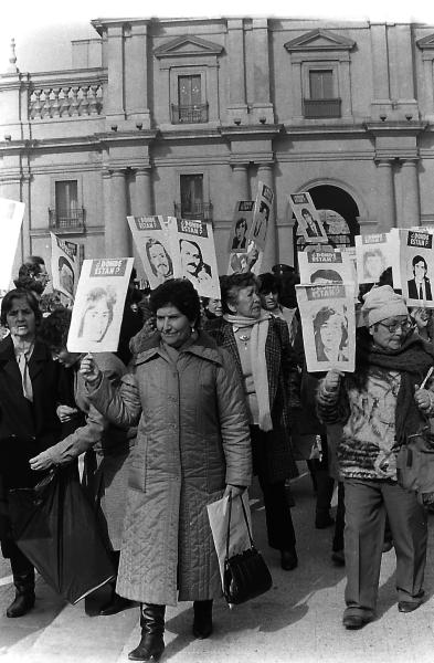 Manifestación de familiares de 119 detenidos desaparecidos, frente al Palacio de La Moneda, con la presidenta de la AFFD, Sola Sierra, encabezando la manifestación. Julio de 1988. Fondo Archivo Fotográfico Fortín Mapocho. CL ARNAD AD-10-FFMAP-S56-NEG/FM NEG 03093. Archivo Nacional de la Administración. Fotografía.