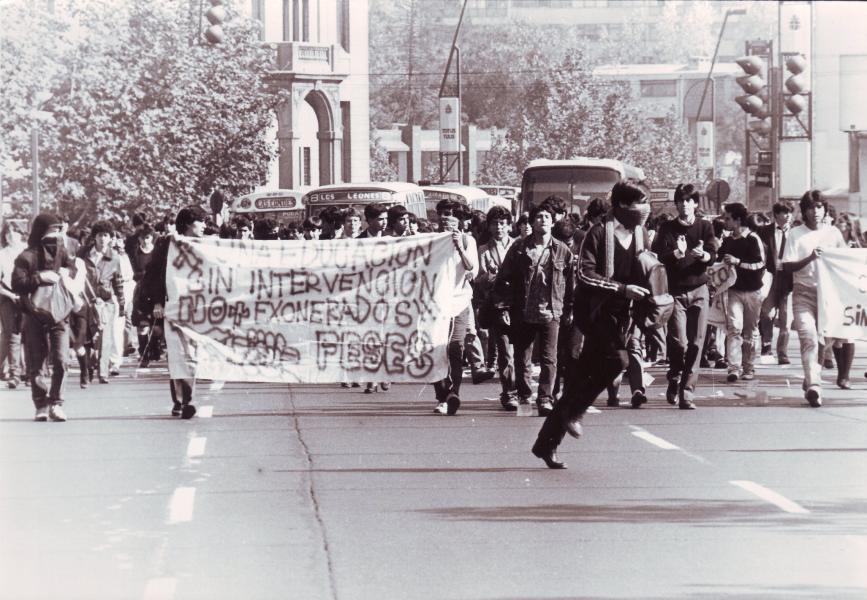Manifestación apoyo a Federación de Estudiantes de Secundario de Santiago (FESES), con lienzo «X una educación sin intervención, No más exonerados». Fotógrafo: Juan Herrera. 8 de julio de 1988. Fondo Archivo Fotográfico Fortín Mapocho. CL ARNAD AD-10-FFMAP-S56-FOT/FM B(04488). Archivo Nacional de la Administración. Fotografía.
