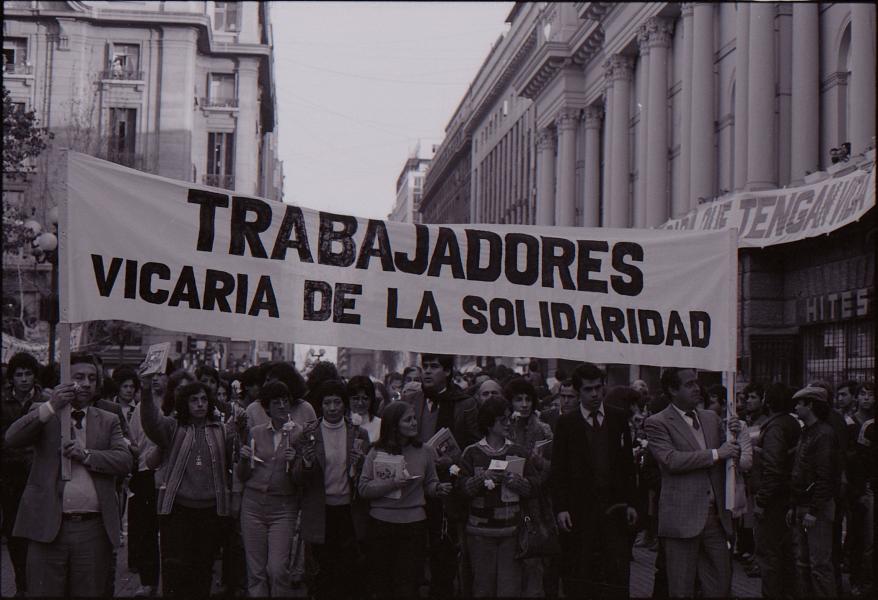 Fotografía manifestación en centro de Santiago, con Trabajadores de la Vicaría de la Solidaridad. Agosto 1983. Donación de Riet Delsing. Fondo Archivo de Mujeres y Géneros. AN CL AMYG RD (C2 S8 211). Archivo Nacional Histórico. Fotografía.